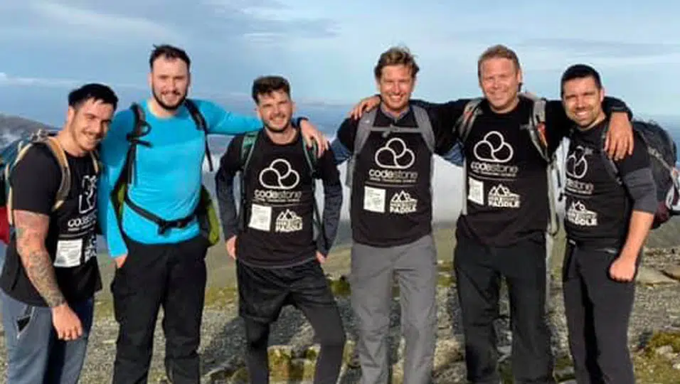 Young men standing outdoors, wearing Codestone shirts.