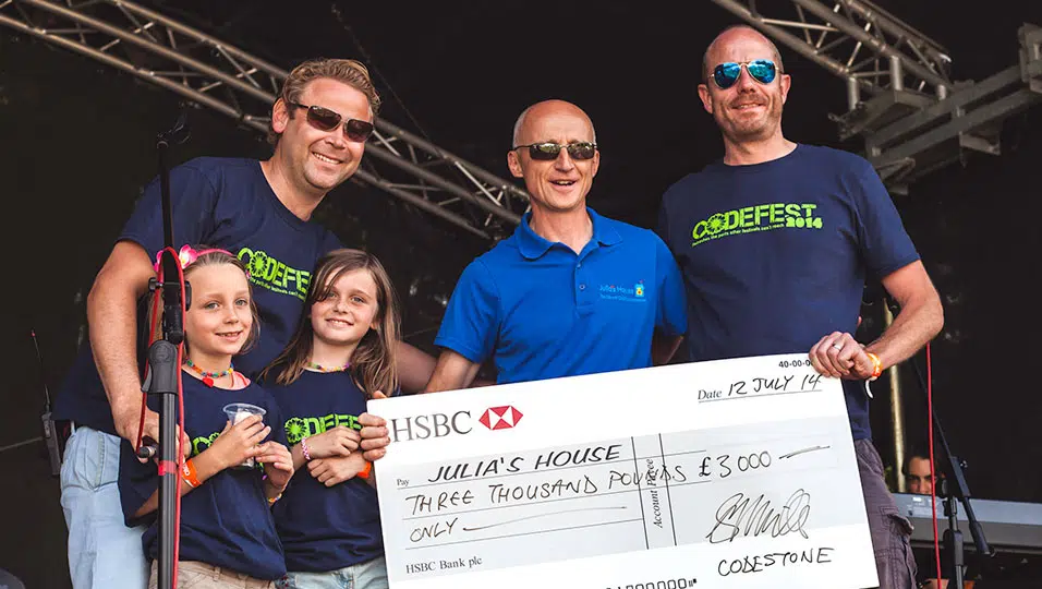 Three men and two girls holding a large cheque for Julia's House.